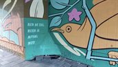Muurschildering van Danny Rumbl, met in het midden de tekst 'Red de zee, neem je afval mee!'